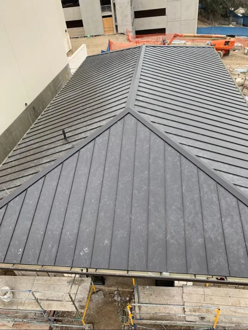 Commercial metal roof construction with crane equipment in Lindale