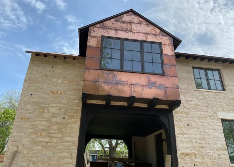 Copper metal panel facade on a stone building for Skylight Installation in Lindale